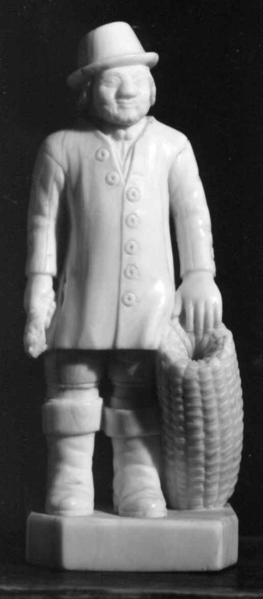 Mannsfigur i elfenben som holder en hummer og en hummertine.