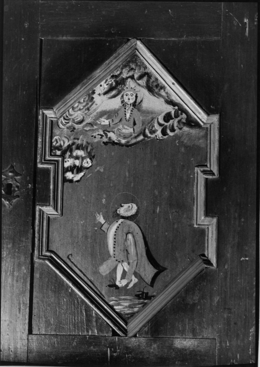 Skap, framskap i en del, to dører oppe og nede. Bibelske motiver; Moses og de ti bud. Gud på en sky, en brennede sky eller busk, en mann som har mistet en sko og en stokk.