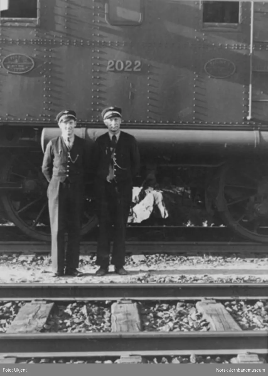 Lokomotivførerne Arne Bringsrud og Kaare J. Teye foran elektrisk lokomotiv type 1 nr. 2022, trolig på Meheia stasjon