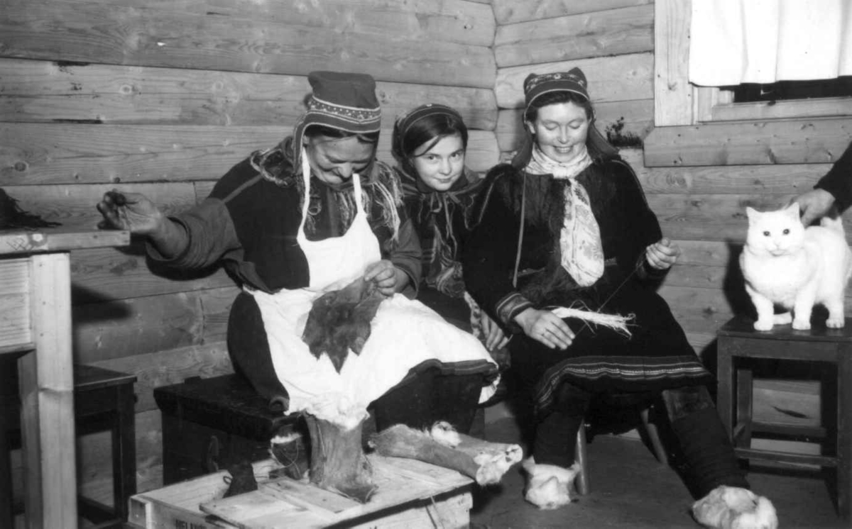 Tre kvinner demonstrerer skinnsøm og senetrådtvinning. Masi.