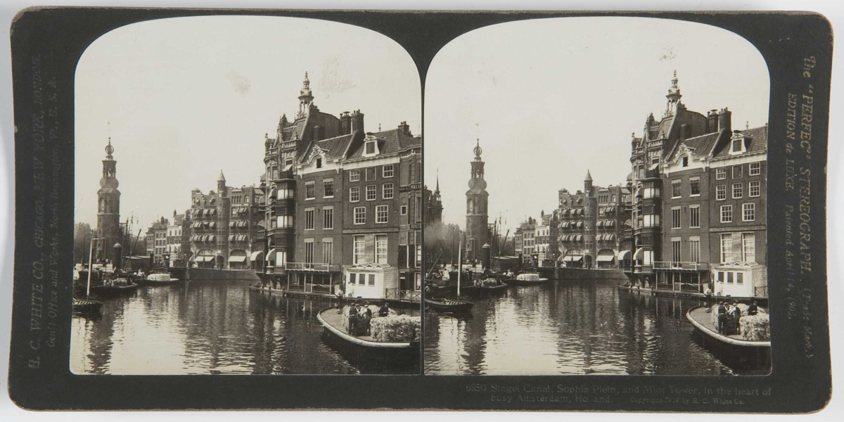 Stereoskopi. Kanal med fraktebåter gjennom bybebyggelse, Amsterdam, Nederland.