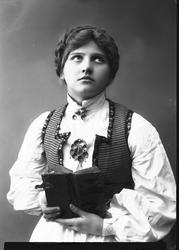 1/2 dels studioportrett av kvinne i drakt med oppsatt hår. H