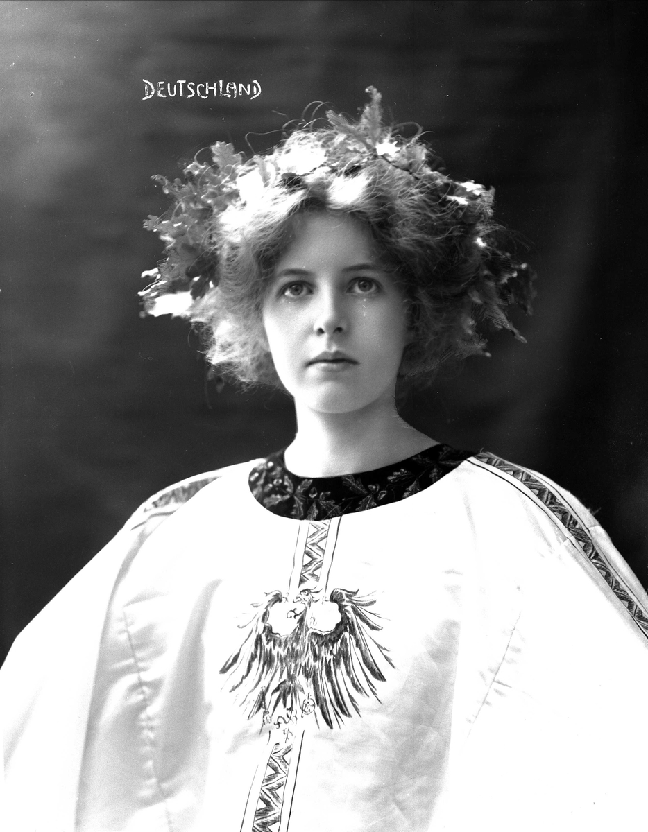 Brystportrett av kvinne i drakt med riksvåpen og hårsmykke. 