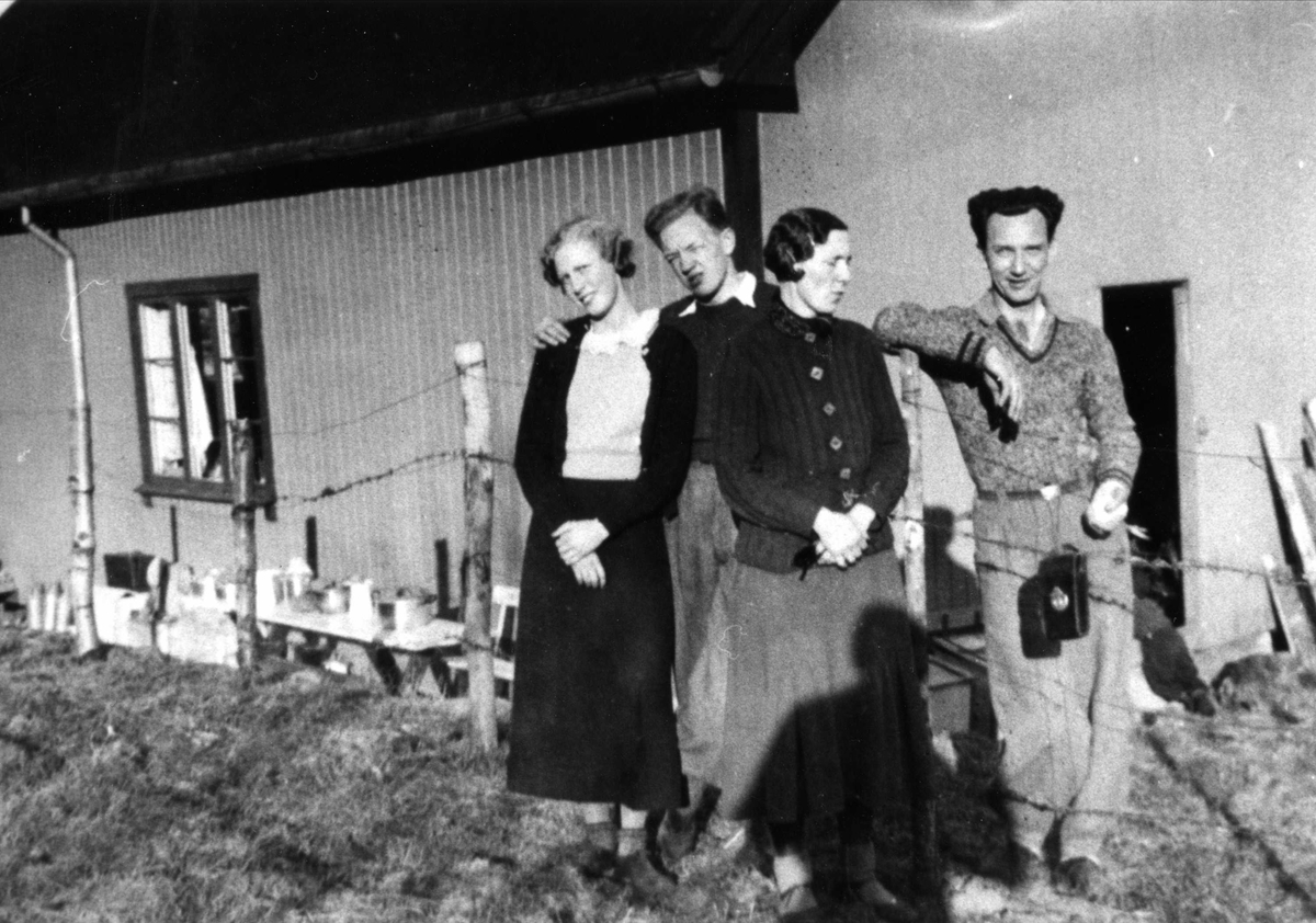 Fire mennesker foran "Primusen" på Oslo Godtemplarungdomslags feriehjem Kirkevik, Nesodden, ca 1940