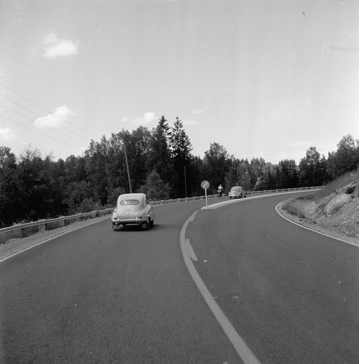 Langs Riksvei 1 i Sverige kjører det to biler på veien. Fotografert 7. juli 1958.