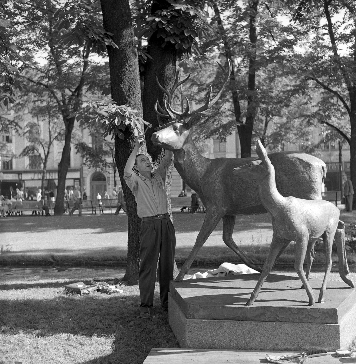 Serie. Siselør Mellin Olsen arbeider på billedhugger Arne Vigelands "Hjortegruppe" på Eidsvolls plass i Oslo. Fotografert juli 1958.

