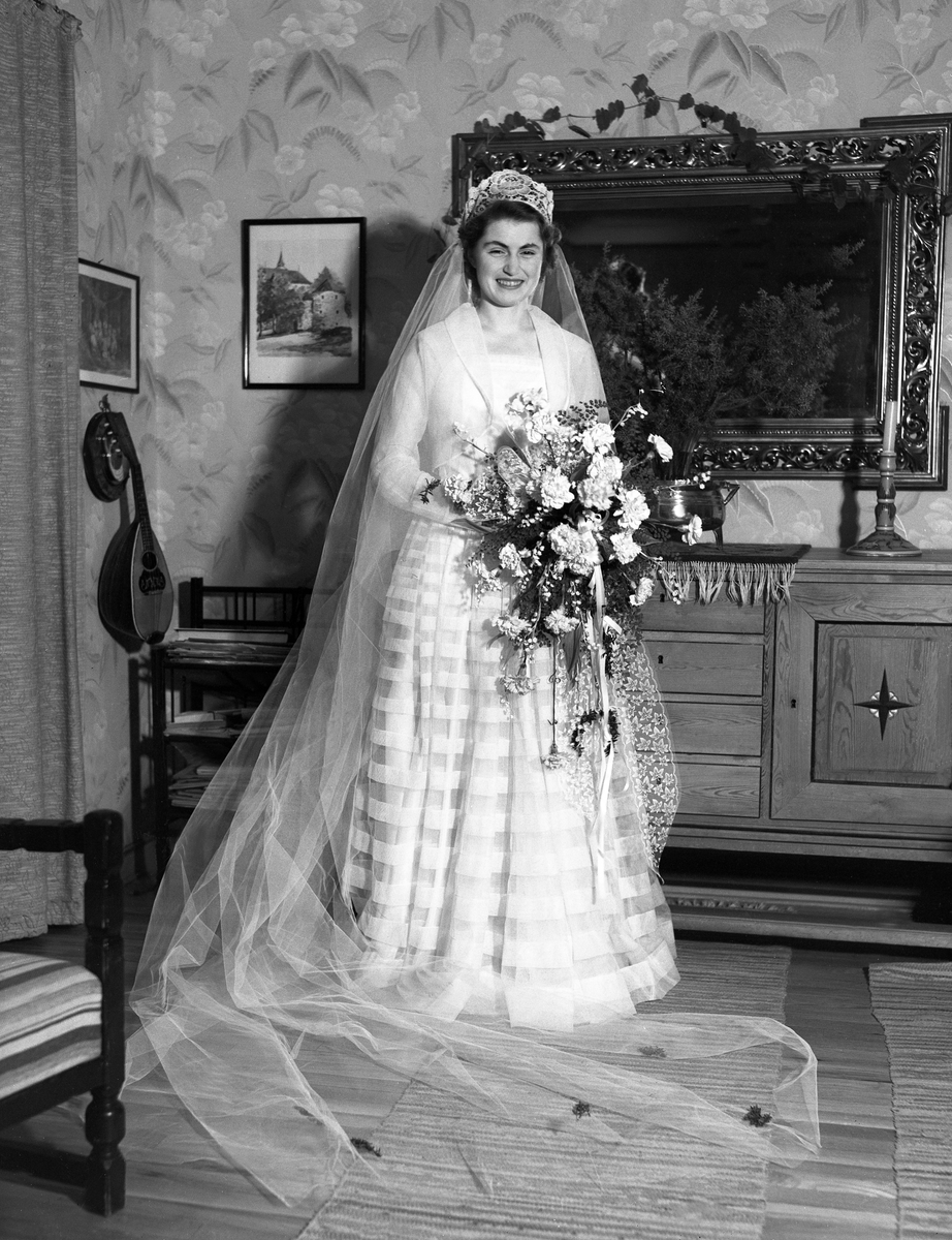 Guri Arenzt står brudekledd i stuen på P.T. Mallingsvei 4, Oslo. Fotografert 1950.