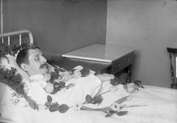 Post mortem-fotografi. Død mann i seng.