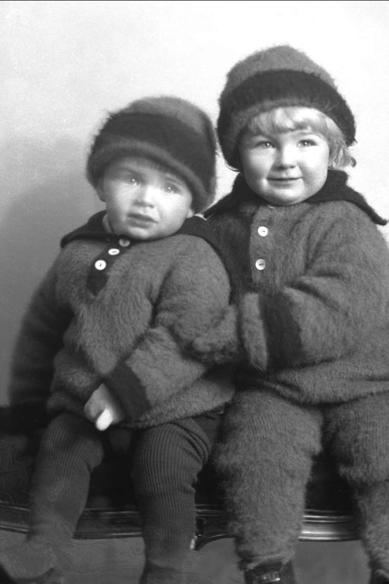 Gruppeportrett, to små barn med strikket jakke og lue. Fru Hagerups barn.