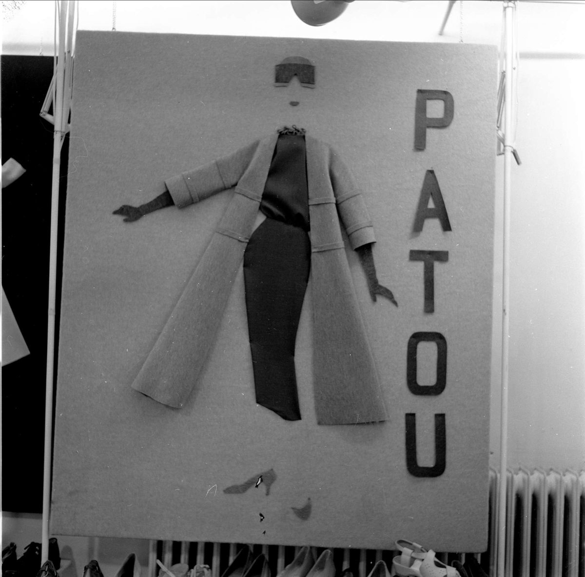 Reklameplakat for klær, tekst på plakat: PATOU. Norsk Mesteråd i sko og stoff, Oslo 07.04.1956.


