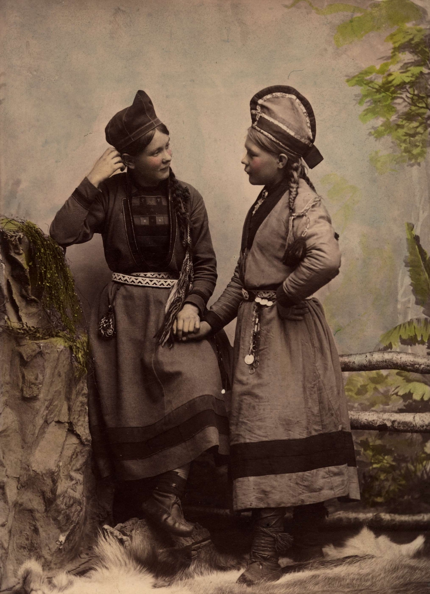 Två samiska kvinnor. Handkolorerat ateljéporträtt i helfigur.