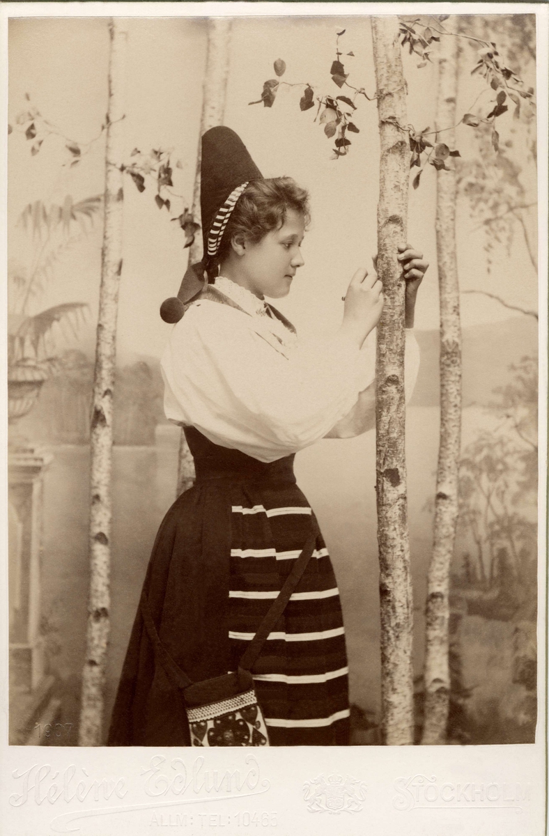 Porträtt av ung kvinna iklädd Rättviksdräkt, Dalarna, som den bars kring år  1900.