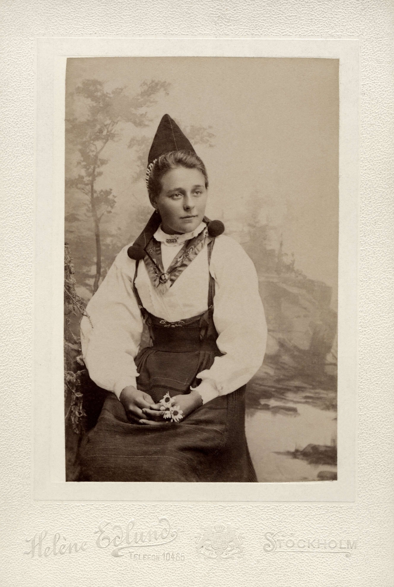 Ung kvinna poserar i en folkdräkt från Rättvik i Dalarna.