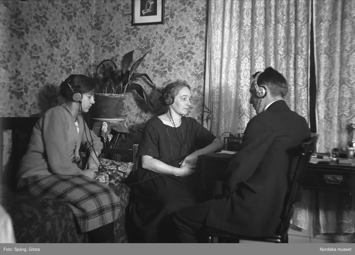Interiör från Klevgränd i Stockholm. Märta, Helga och Birger lyssnar på radio 17 november 1925 kl 09:40.