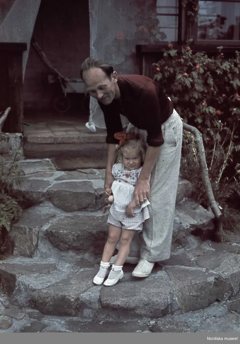 En man med en liten flicka på en stentrappa.