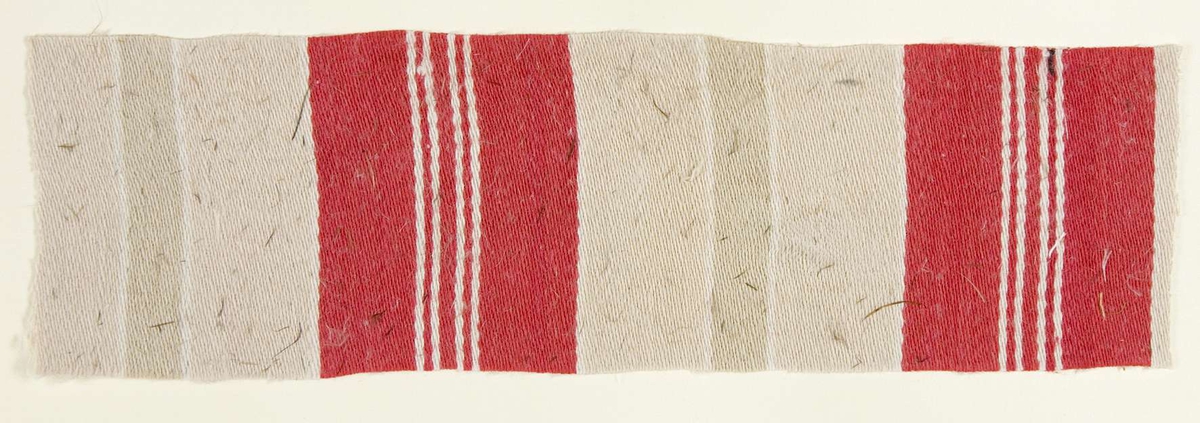 Vävprov ämnat för bolstervarstyg vävt i korskypert med bomullsgarn. Randigt i vitt, grått och rött. Vävprovet är uppklistrat på en kartong i storleken 22 x 28 cm. I övre högra hörnet finns en stämpel "Uppsala läns hemslöjdsförening" och ett handskrivet nummer, "A.1541"