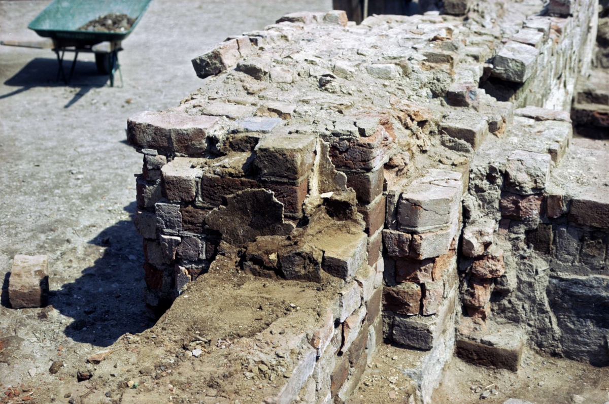 Arkeologisk undersökning av Franciskanklostret, kvarteret Torget, Uppsala 1971 - 1972. Mittskeppet, travé 1. Södra väggen, igensättning under rivning. Från västsydväst