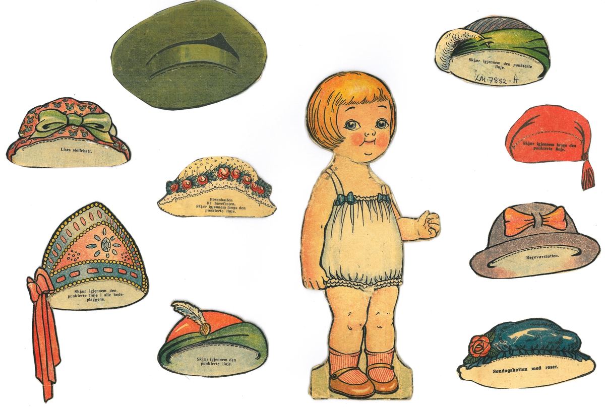 Papirdukke med 9 hatter/lue og 9 kjoler. Delene er klipt ut frå utklippsark og dukken er montert på papp. Hatt C er frå avis/magasin.

A- dukke, jente med lyst hår, 21 x 10 cm
B- kjole, grønn og gul, 10 x 9 cm
C- hatt, grønn 7 x 10 cm
D- kjole, russisk nasjonaldrakt, 10,5 x 10 cm
E- lue til D, 7 x 8 cm, bånd 7,5 cm
F- ettermiddagsdrakt, rød, grønn og blå, 11 x 7,5 cm
G- hatt til F, 5 cm x 7,5 cm
I- formiddagskjole, 8,5 x 9 cm
J- hatt med rosebord, 4 x 7,5 cm
K- lekedrakt, 10 x 7,5 cm
L- selskapskjole, rosa med blå blomster, 9 x 8 cm
M- hatt til L, 4,5 x 8 cm
N- kåpe, blå med paraply, 11 x 8 cm
O- hatt, blå med rose, 4,5 x 8,5 cm
P- kjole, grønn med rød jakke, 10 x 7 cm
Q- lue, rød med dusk, 4 x 5,5 cm
R- kimono, 14 x 8 cm
S- hatt, lilla med rød sløyfe, 4,5 x 8 cm