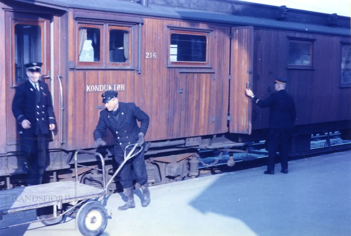 Gjøviktoget ekspederes på Gran stasjon. Vogn for konduktør. Mann med tralle. Stasjonsmester