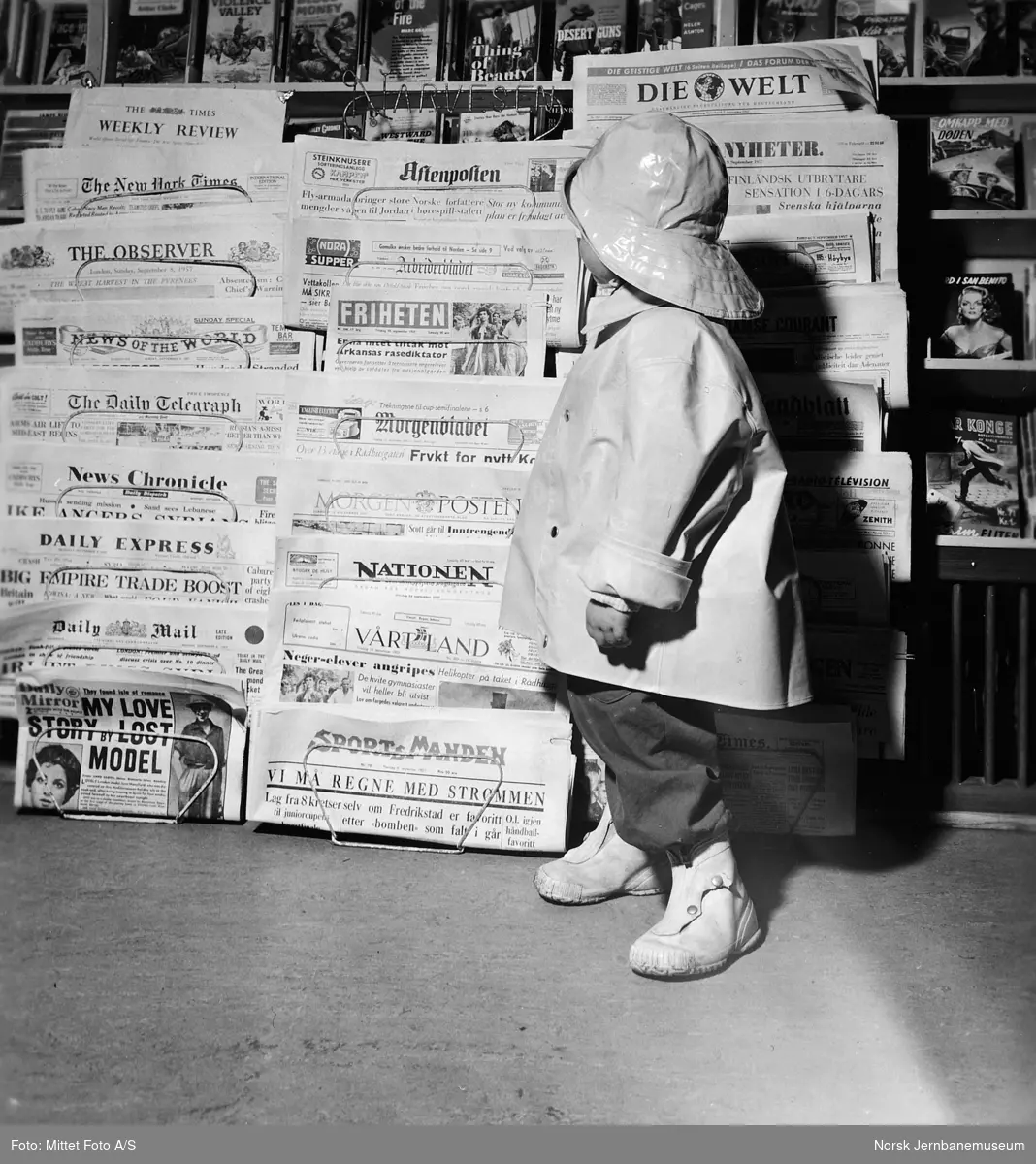 Narvesen-kiosk med et barn ved avisstativet