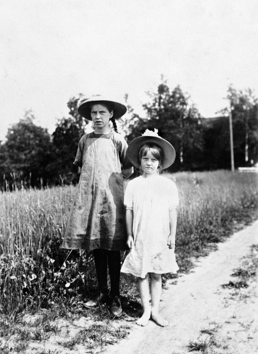 To jenter med kjoler og hatter. Oddlaug Trønnes og Solveig Trønnes.