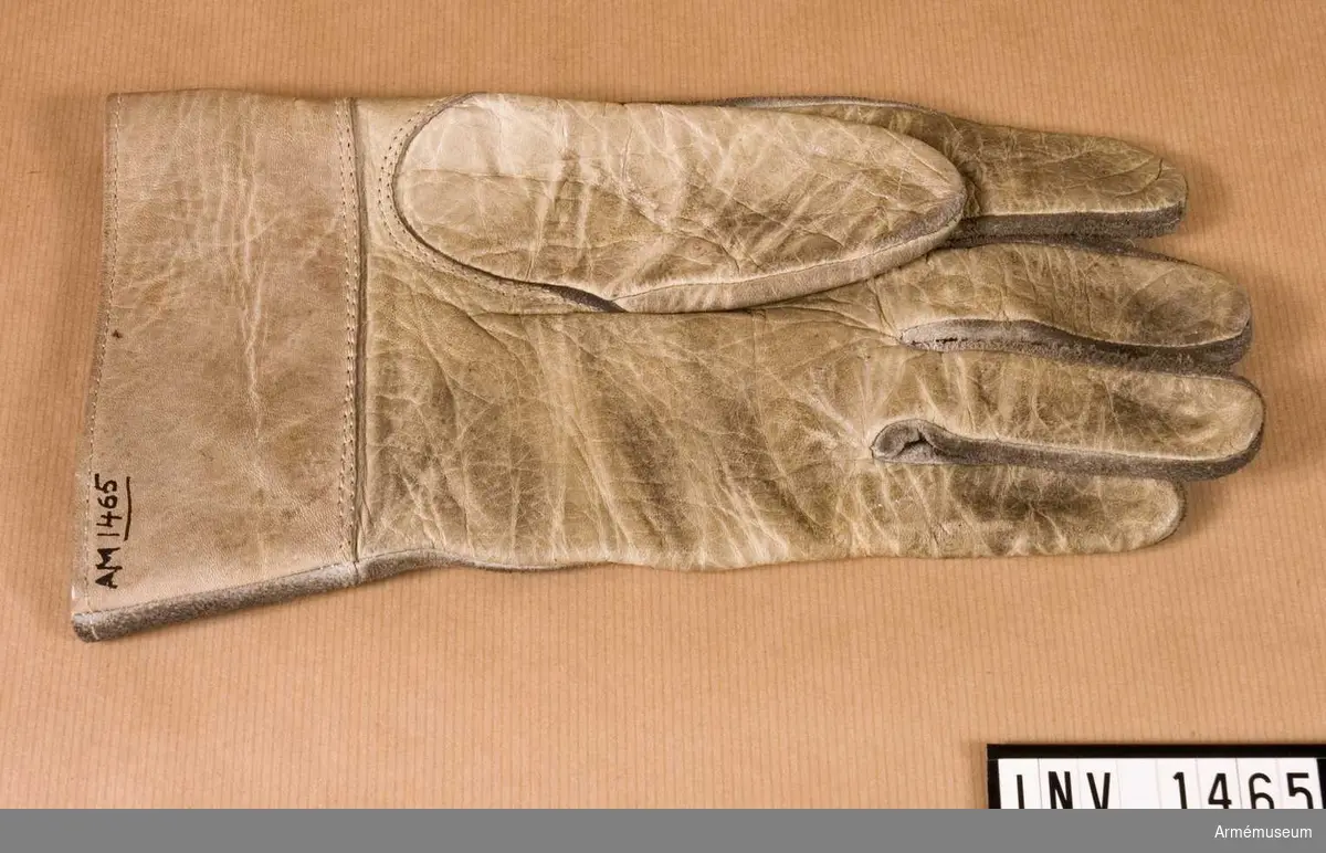 Handske m/1938, ytter-, Vänster. Av vitt skinn, blankt på handens innersida. Vid handleden en 55 m hög krage.