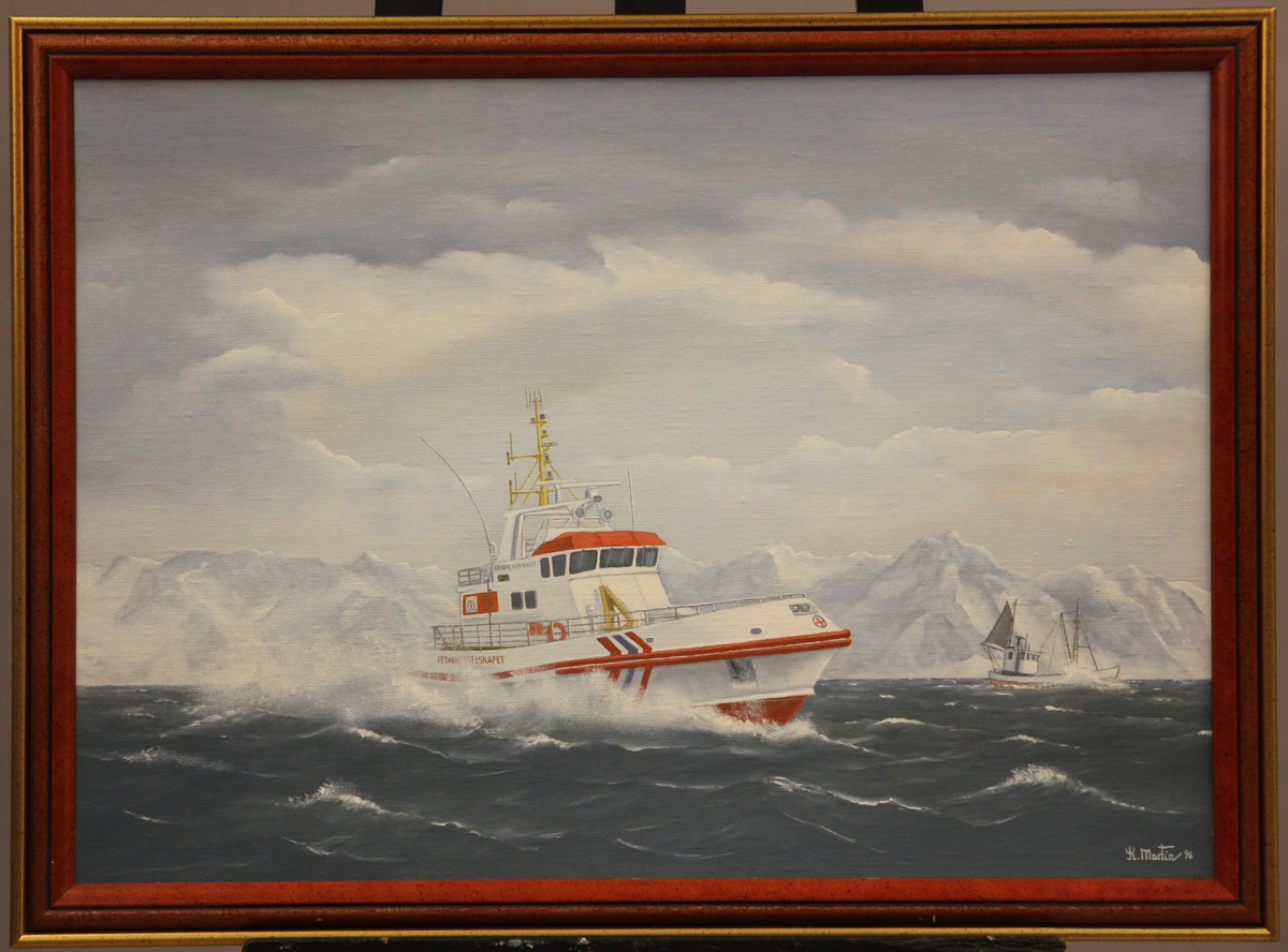 Redningsskøyte "Reidar von Koss" i sjøen. Fiskeskøyte og snødekte fjell i bakgrunnen.