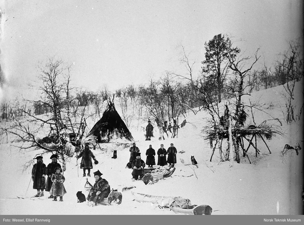 Teltplass med folk og et fjellfinnetelt i fjellet ovenfor Sandnesdalen, Sør-Varanger, Finnmark, i 1897.