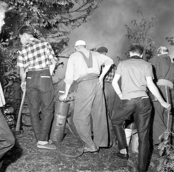 Brandmän och allmänhet bekämpar en eldsvåda i Dalaberg, i norra delen av Uddevalla, juni 1958