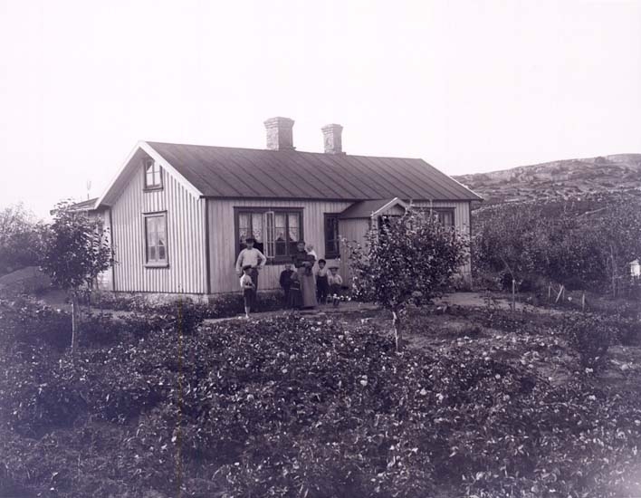 Familjen Hedberg vid sitt hus med trädgård