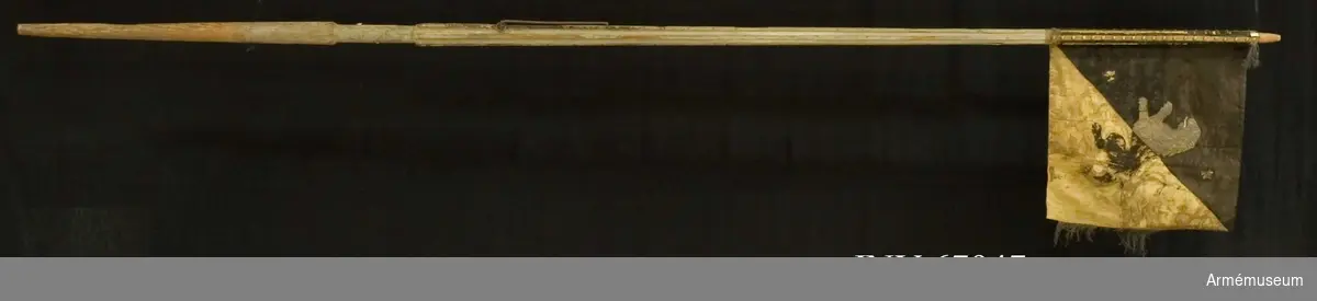 Duk: Tillverkad av dubbel damast, det svarta fältet med taft, vapensidans svarta fält med atlas och gula fält med sidenkypert. Duken fäst vid stången med tre rader tennlikor på gula sidenband.

Dekor: Diagonalt delad i två fält på inre sidan, det övre svart, det nedre gult med broderat upprätt lejon i guld och svart med guldkontur på det gula, följt av två rosformiga stjärnor i silver (Västergötlands vapen).

På den yttre sidan det nedre inre fältet gult, det övre yttre svart, samt i guld inom krans av palmkvistar, nedtill hopknutna, A med dubbelt F (Adolf Fredriks namnchiffer) på ljusblått fält (numera bara fragment av det blå); över kransen sluten kunglig krona.

Frans: Spår av guldfrans längs den vertikala kanten. 

Stång: Tillverkad av trä, kannelerad, vitgråmålad; löpande bärring, saknar holk och spets. 

Etikett med text på stången.