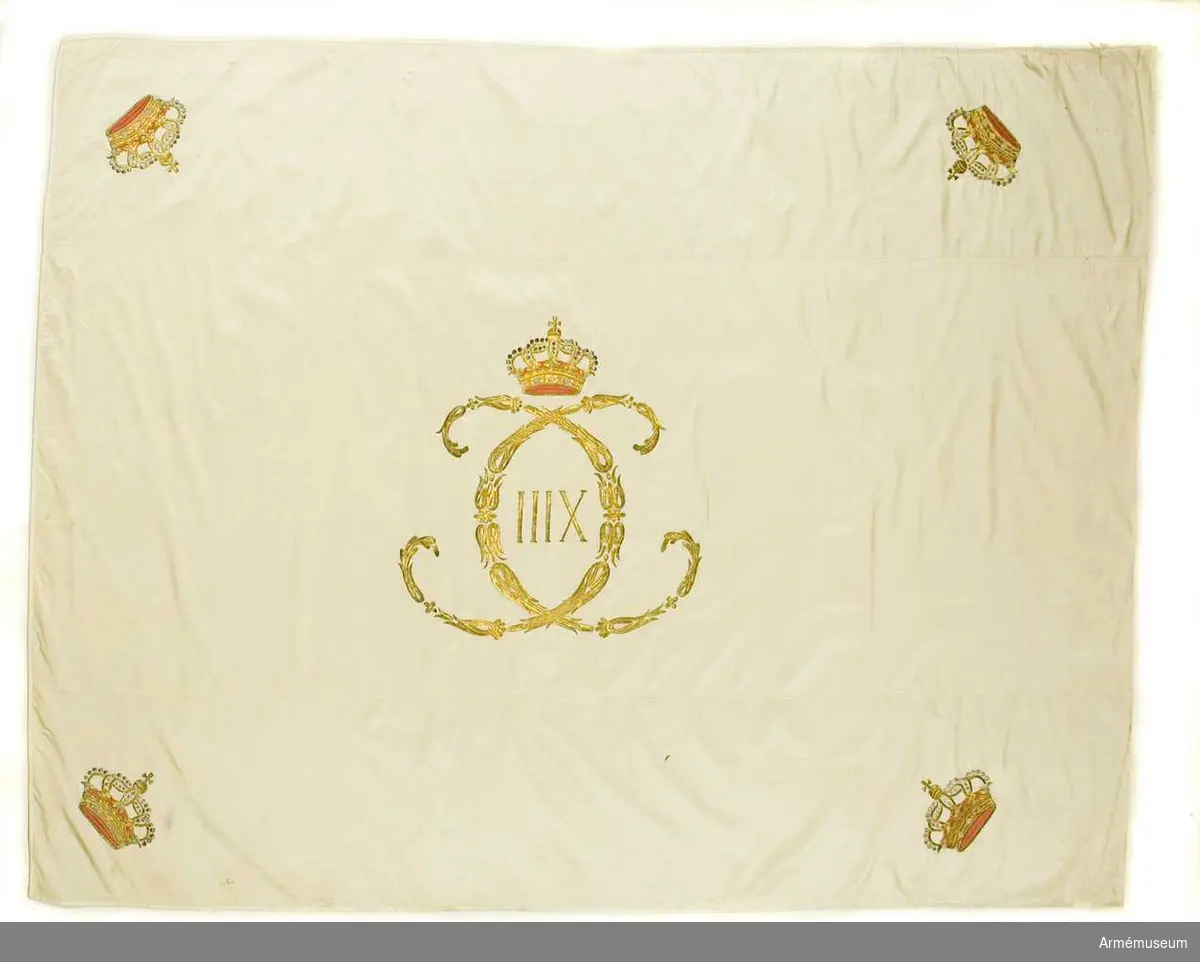 Duk: Tillverkad av vit sidenkypert med konungens krönta namnchiffer, broderat i plattsöm, h: 55 mm. Sluten krona i varje hörn. Duken sydd av tre längsgående våder.