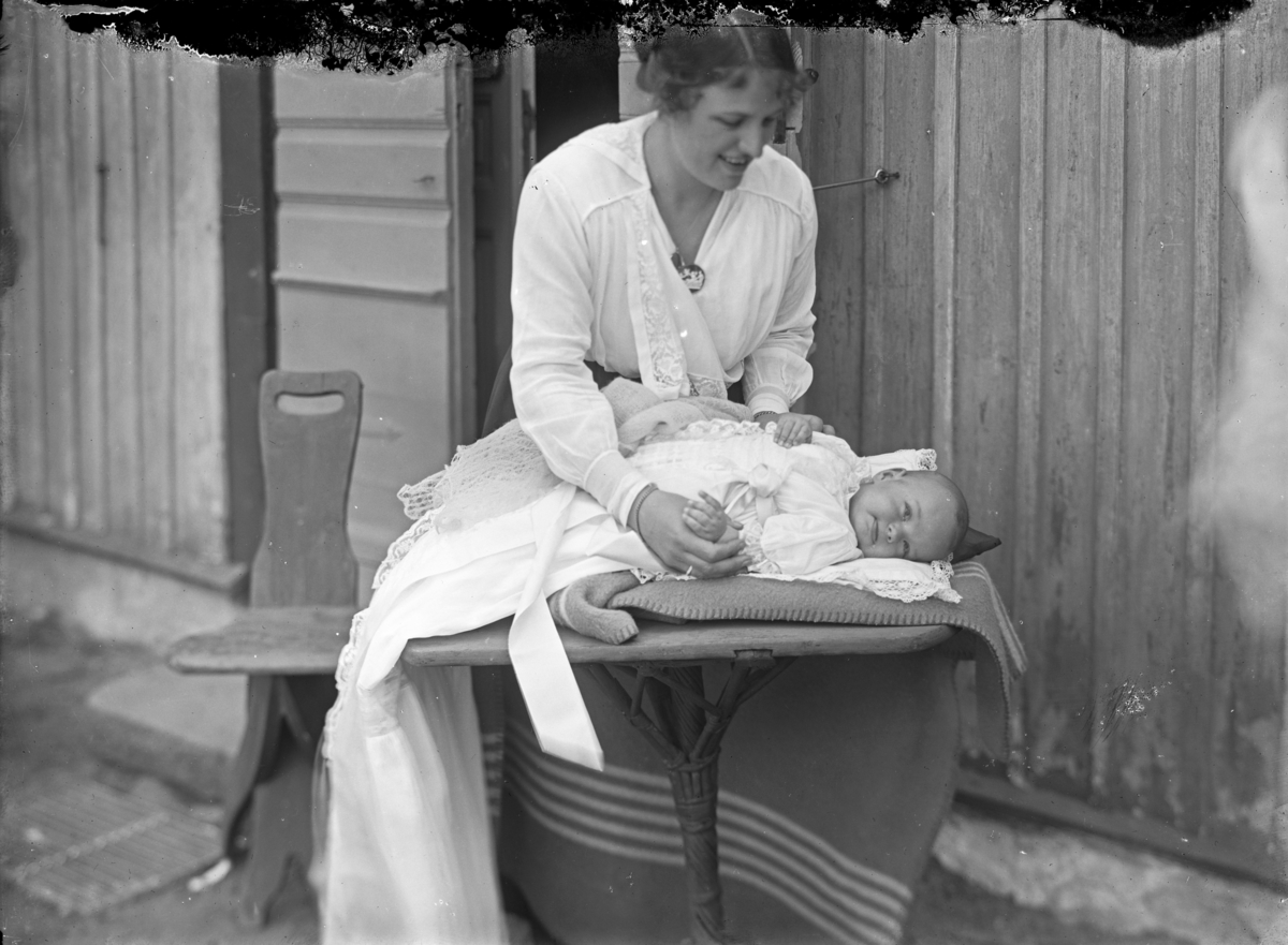 Kvinna med ett barn (i dopklädsel?), troligen 16 maj 1918