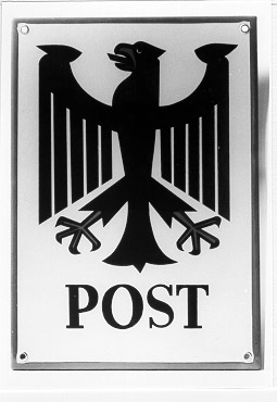 Postkontorsskylt från Västtyskland, rektangulär, tillverkad
iemal- jerad plåt. Motivet; den tyska örnen i svart mot gul
bakgrundoch texten "POST" i antikvastil i nederkanten. Skylten
inramas av ettsmalt rött fält. Ett mässingringförstärkt hål i
respektive hörn.
