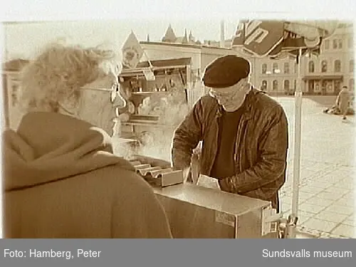 Dokumentation av  korvgubbarna i centrala Sundsvall.  Anton Olsson vid sitt korvstånd och några av hans kunder.