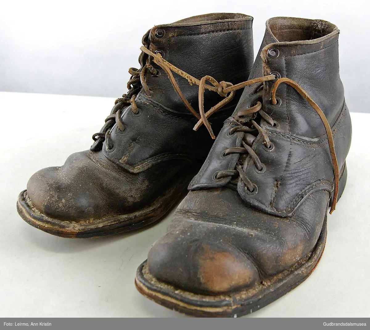 Ett par sko i lær, flate såler som er naglet og sydd til skoene, med knytting. 