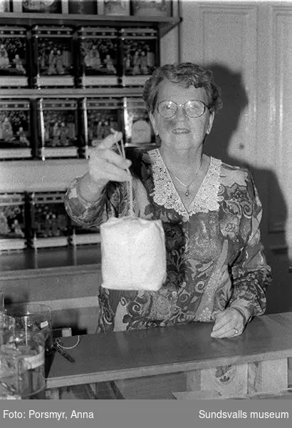 Kaffeaffären IDO, Nybrogatan. Bildsvit gjord för dokumentation utförd 1996. Affärsrörelsen grundades av Carl Dahlström den 18 november 1931. Dahlström föddes i Närsta, Alnö. Han arbetade som kassör på Hörningsholms sågverk 1918 till 1930 då sågen lades ner. Han fick inspirartion att starta kaffehandeln av sin bror Erland som arbetade på Kolonialvaruaktiebolaget. Mellan 1931 till 1937 drev Dahlström kaffehandeln tills en anställd, Eva Farm, tog över som nästa ägare. Sune Bäckström som tidigare arbetat som springpojke på firman tog över verksamheten 1954. Rosteriet som tidigare låg i magasinskvarteren (nuvarande Kulturmagasinet) flyttades 1983 till innergården vid Blombergska huset och en specialbyggd skorsten fick uppföras. Tonvikten på försäljningen ligger numera (2020) på ett välsorterat utbud av olika tesorter.