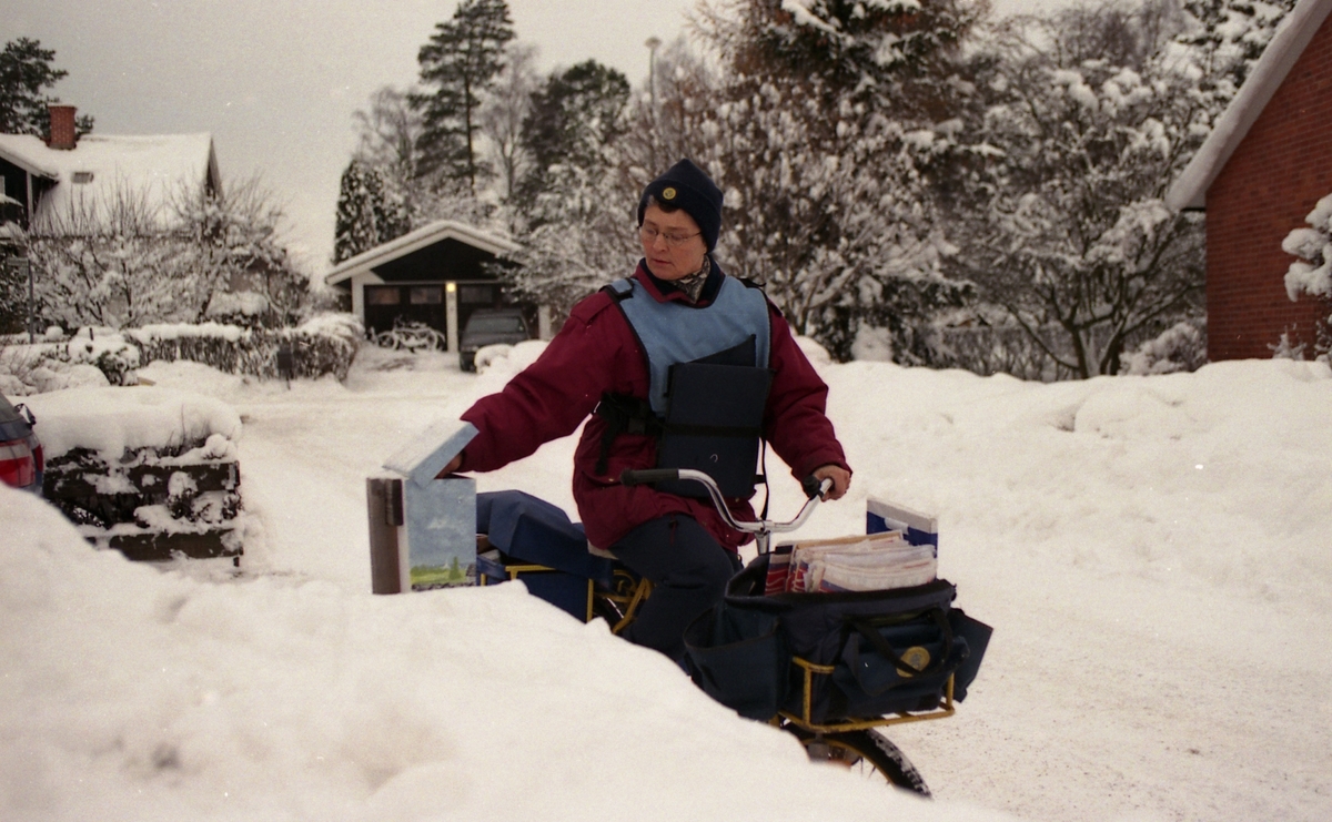 Cyklande brevbärare Elisabeth Ekvall lämnar post i postlåda på Radvägen i Knivsta.