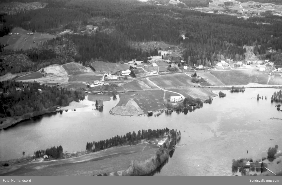 Flygfoton över Stöde och Stödesjön med högt vattenstånd. Översvämmade hus och vägar.