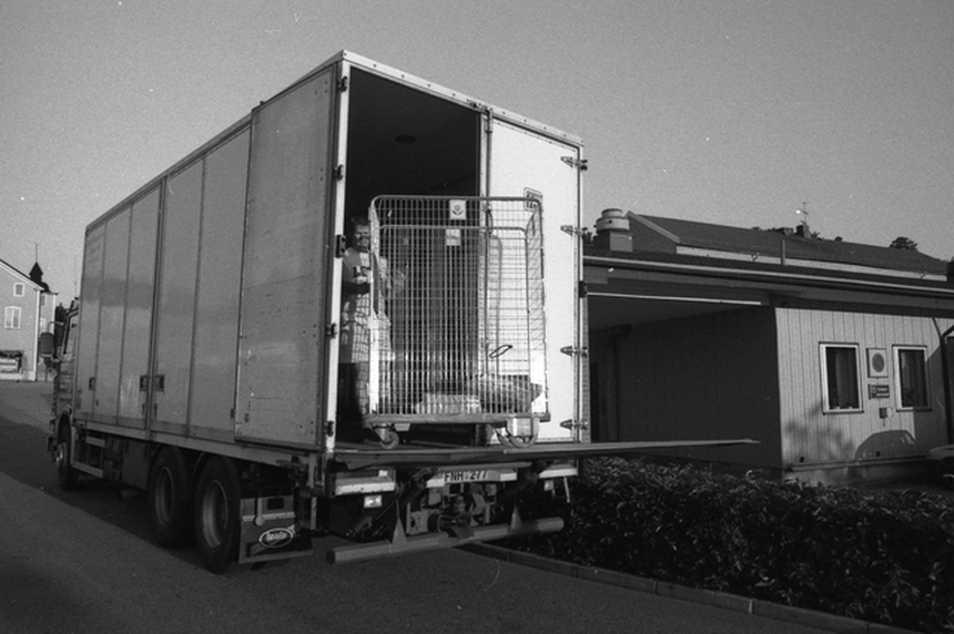 En postbehållare lastas på lastbil.
