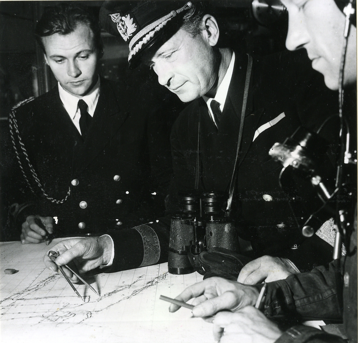 Konteramiral Erik af Klint och adjutanten Lt. Nils Hellström samt okänd 3:dje man plottar kursen ombord på kryssaren Tre Kronor.