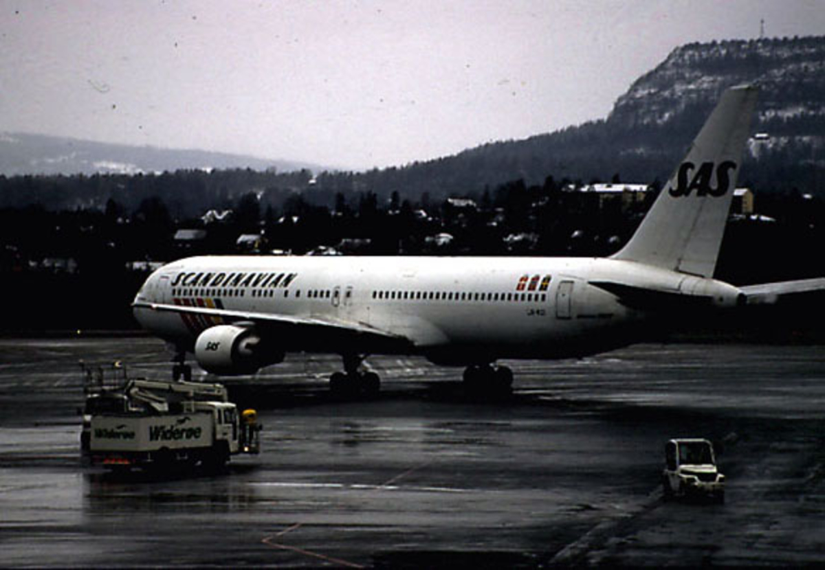 Lufthavn, 1 fly på bakken, LM-RCI Boeing 767 - 383ER "Helga Viking" fra SAS, set fra siden. Kjøretøy ved flyet.