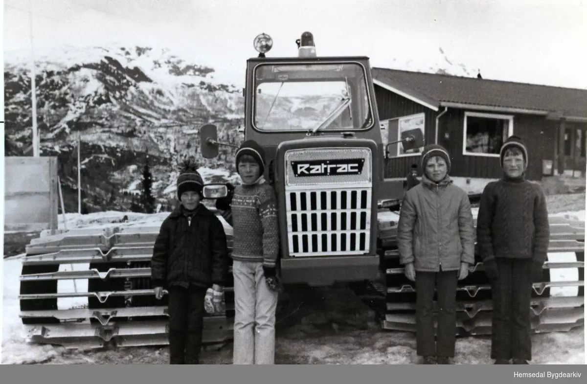 Frå venstre: Bjørn Dokk, Ola Terje Dokk,Jorunn Holde og Gunnbjørg Dokk framfor "Laura", den fyrste trakkemaskina med metallbelte. Trakkemaskina vart kjøpt i 1969.
Biletet er teke i 1970.
