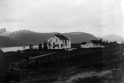 Lensmannsgården i Tysfjord. I forgrunnen en kvinne med barne