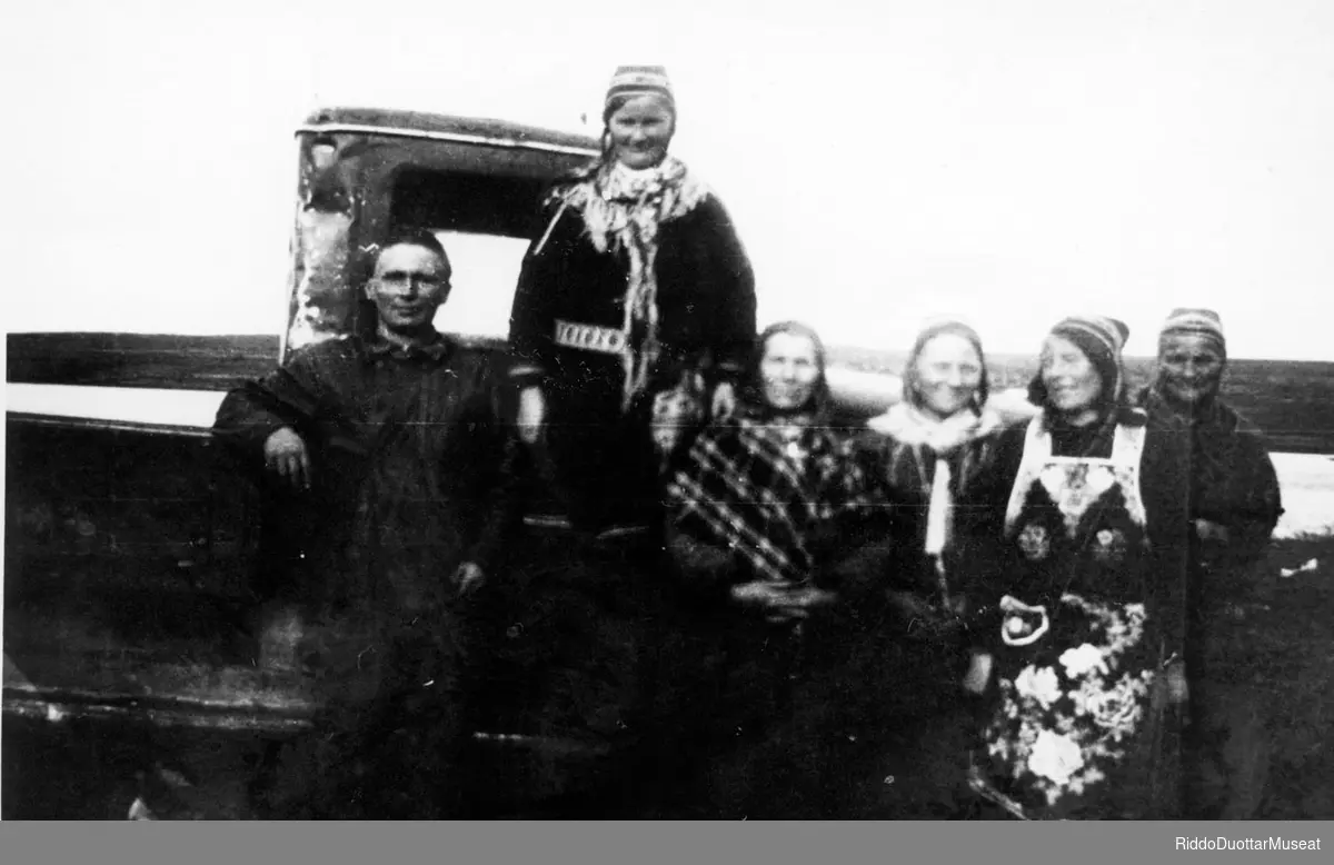 Dievdoolmmoš ja vihta nissonolbmo cuccot guorbmebiilla guoras.
En mann og fem kvinner poserer foran et lastebil.


Binges-Risten.
