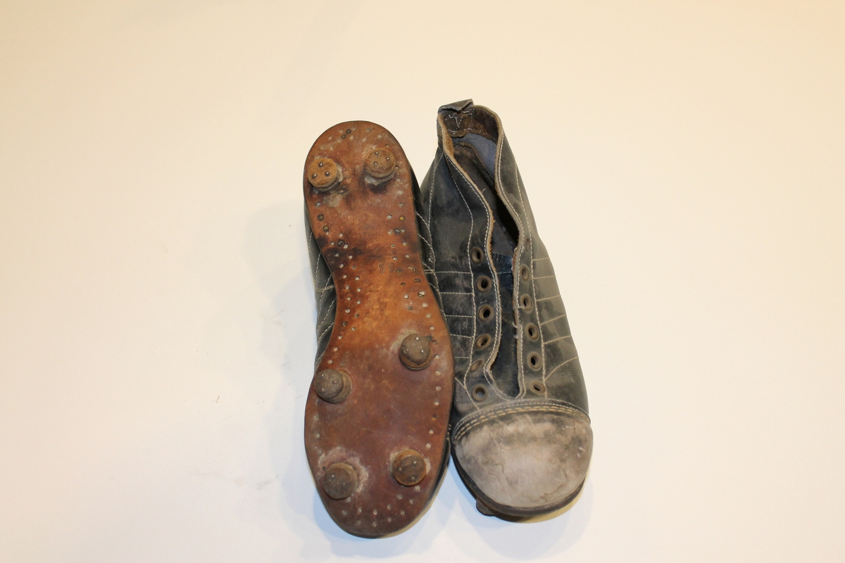 Par med brune fotballstøvler i lær fra 1940-50-tallet. Skoene er av typen man måtte smøre inn med vaselin. Knotter som er spikret på