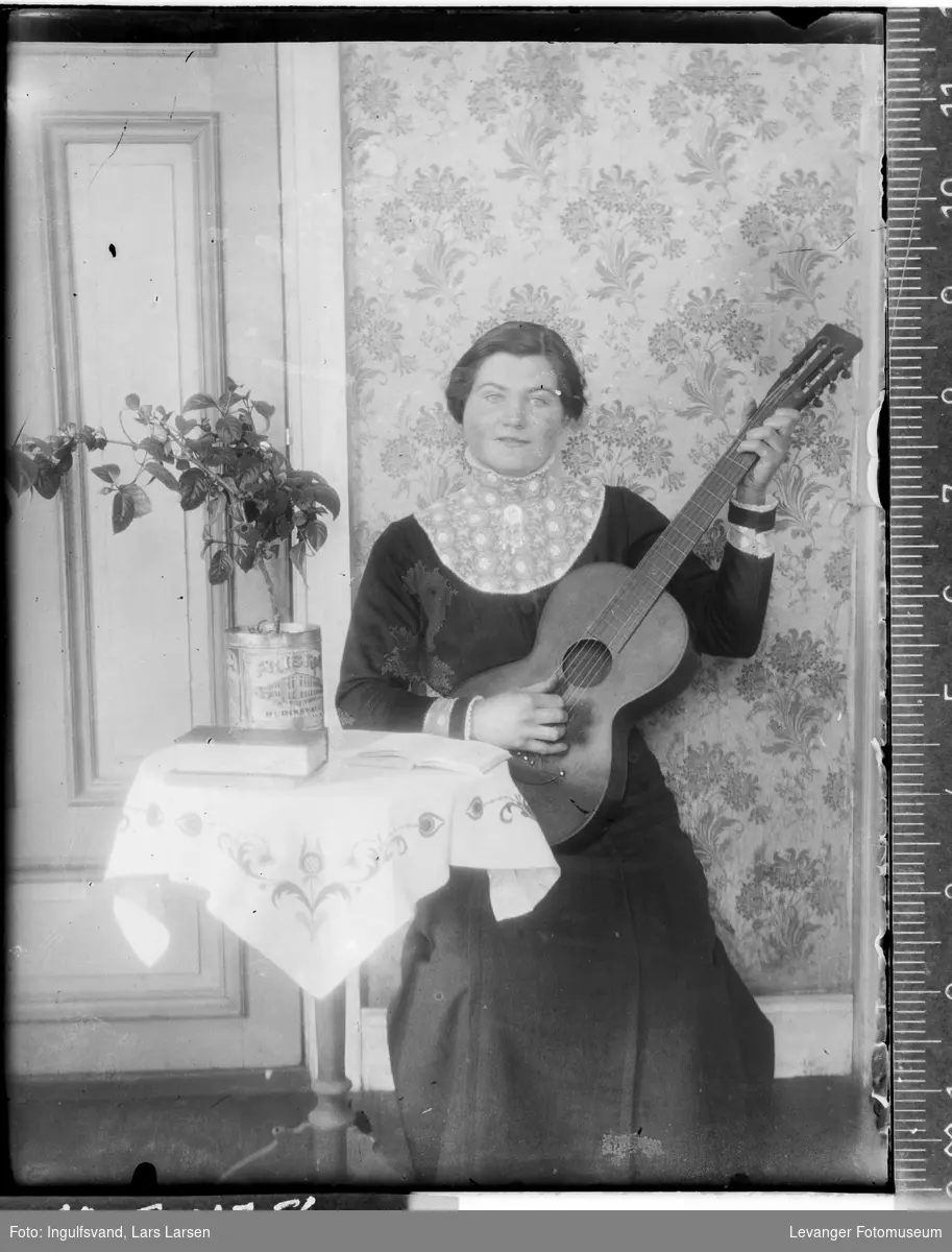 Portrett av en kvinne som spiller gitar.