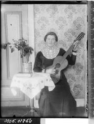 Portrett av en kvinne som spiller gitar.