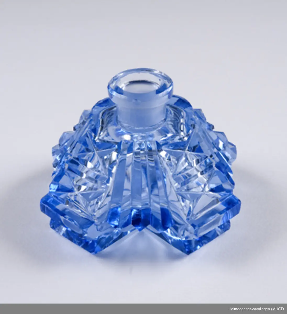 Parfymeflaske av slipt blå krystall, merket med Made in Czechoslovakia, etset inn under, mer modern merke. Stopperen mangler. Forseggjort flaske. Fasettsliping.