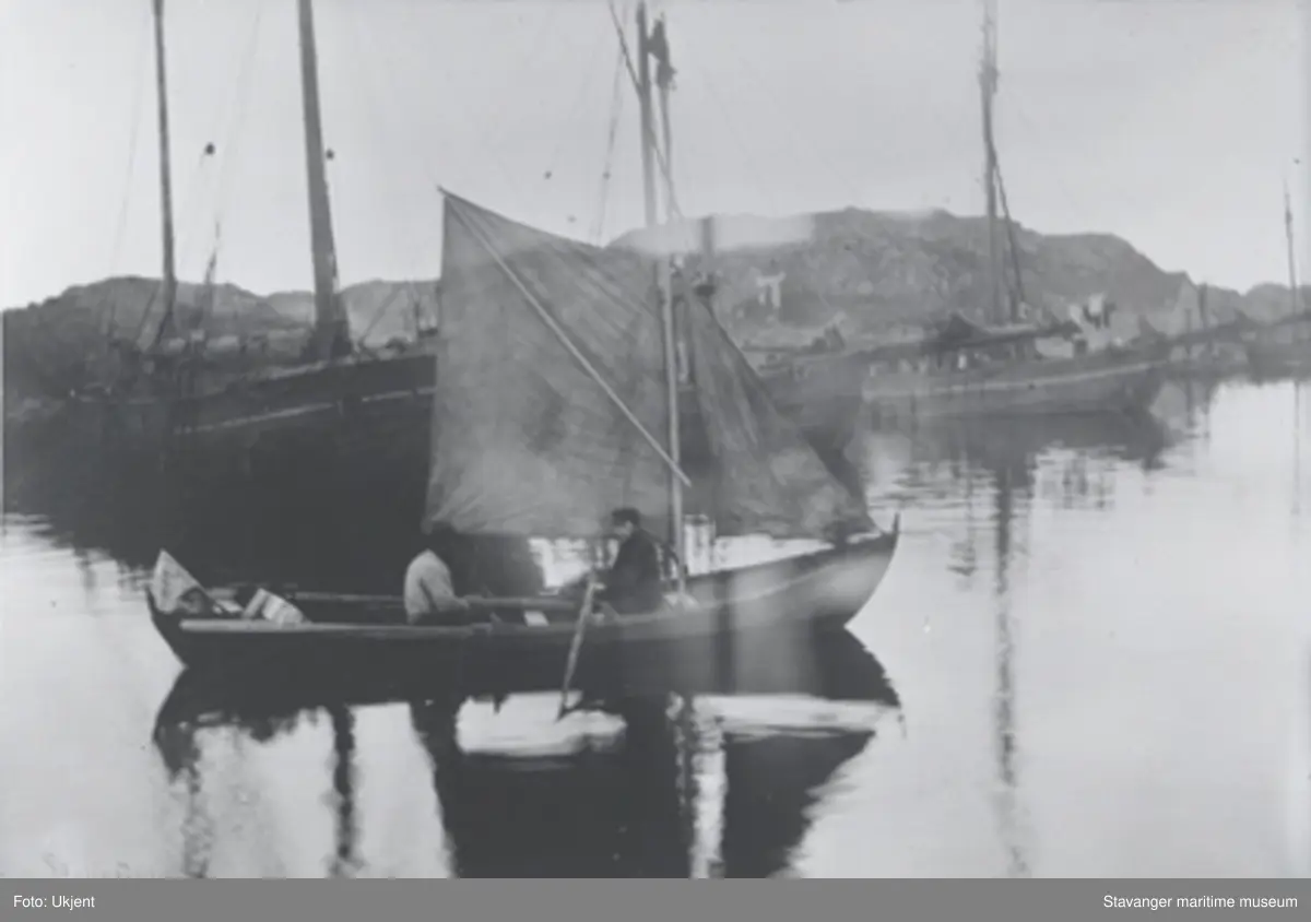 Reprofoto av bruksbåt, en færing med seil og årer. To menn i båten ...